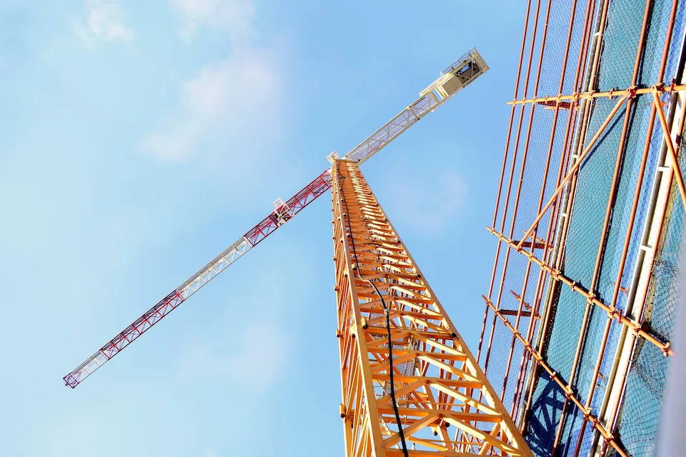 Tower crane positioned beside scaffolding systems at a large construction project in Stockton