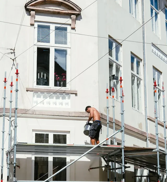 Contractor performing exterior building maintenance using scaffolding platforms in Stockton