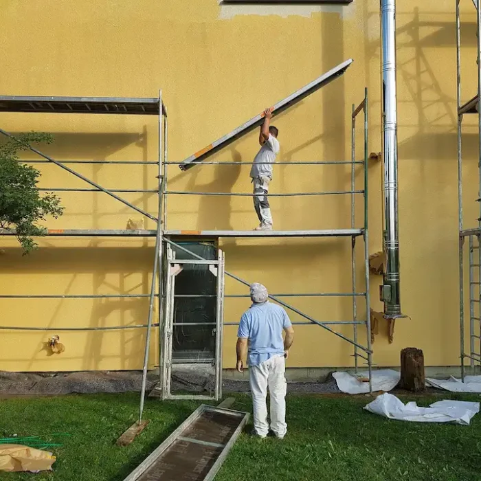Professional workers assembling scaffolding systems for residential exterior construction in Stockton